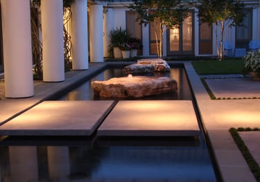 arbor mounted down lights illuminating a path over water fountain