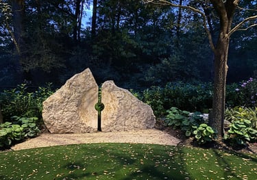 accent light installed on tree to illuminate a stone feature