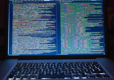 Lifestyle image of a laptop keyboard and screen with colorful yellow, green, and blue coding text.