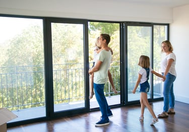 Familia disfrutando de puerta balcón plegable en aluminio con baranda de vidrio — Aberturas Gala GBA
