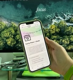 celular frente a un monitor enseñando una plantilla de notion de propósitos y metas