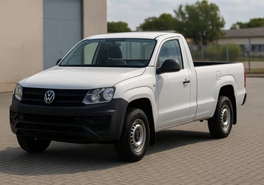Volkswagen Amarok cabine simples branca estacionada em pátio, vista de frente e lateral direita