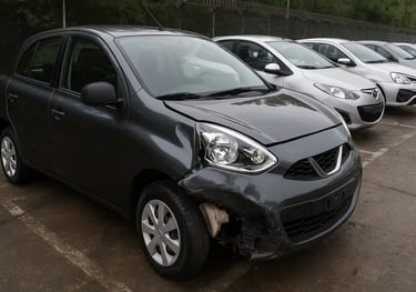 Carro popular usado no Brasil com frente danificada estacionado em pátio de veículos