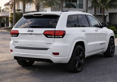 Jeep Grand Cherokee 2015 branco visto pela traseira em ângulo lateral mostrando design de SUV de lux