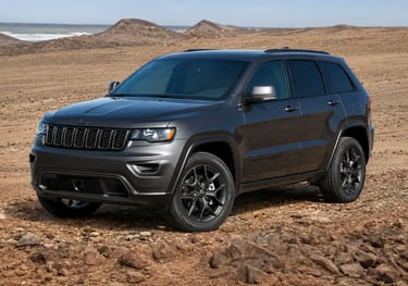 Jeep Grand Cherokee cinza estacionado em terreno rochoso no deserto