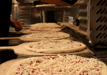 several cheese pizzas ready to put in the oven