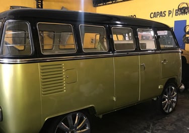 Vista lateral externa de uma VW Kombi customizada dentro da Tapeçaria Capotaria Agacildo.