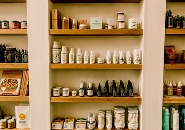 Natural skincare products and organic beauty supplies neatly displayed on wooden shelves in a boutique store.