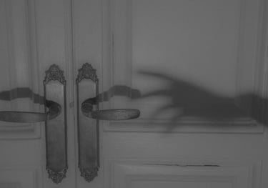 un fantôme sombre qui atteint la poignée de la porte