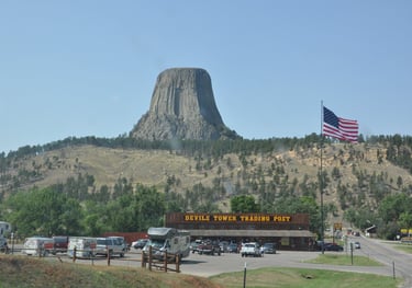 a mountain view of devils tower with a flag flying in the air