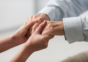 aidant tenant les mains d'un senior aidé alzheimer
