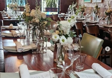 Elegant table setting rentals in Toronto featuring white floral centrepieces, glassware, candles, an