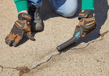 Prepping driveway for sealcoat and crack repair by removing debris