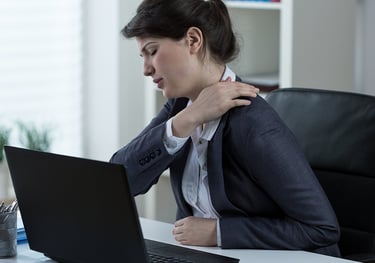 Trabajadora con dolor de espalda por accidente laboral en oficina solicitando ayuda