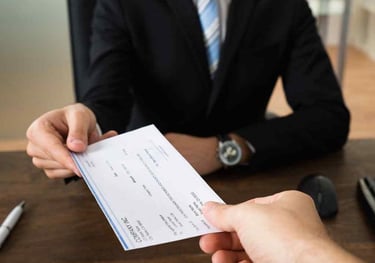 Abogado entregando cheque por pago de salarios y beneficios laborales pendientes