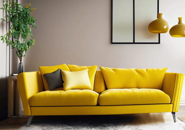 a yellow couch in a living room with a plant in the background