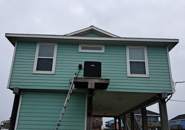 a man standing on a ladder ladder to repair an AC Unit