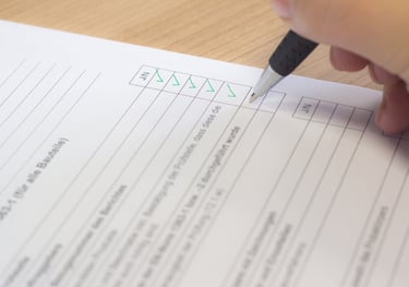 a person holding a pen and writing on a paper