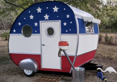 Red, white and blue American Flag Themed Custom Painted Camper complete with falling white stars