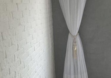 a white curtain with a curtain hanger in a room