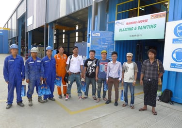Industrial workers posing for a photo at a Jotun blasting and painting training course facility.