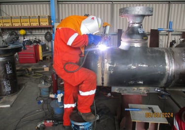 Professional weldere  performing industrial pipe welding in a workshop.