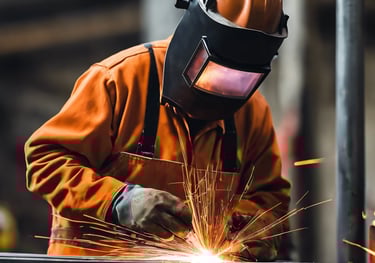 a man in a welding helmet welding a piece of metal