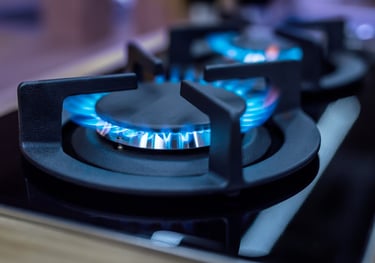 a gas stove top with blue flames on a stove top