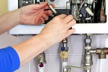 a person is fixing a water heater