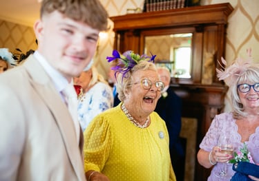 Guests share laughter at a wedding reception in Decourcey’s Manor, Cardiff, full of colour, joy and character.