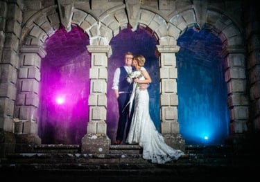 a bride and groom standing in front of a castle