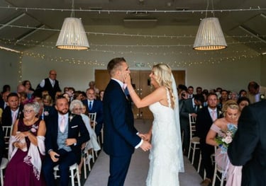 a bride and groom kissing in a wedding ceremony