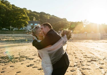 a bride and groom kissing on the beach