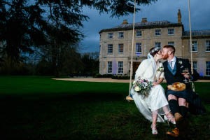a bride and groom kissing on a swing swing