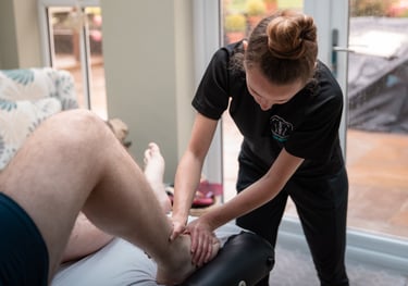 Sports Therapist conducting an ankle injury assessment on a client