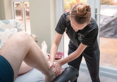 Sports Therapist conducting an ankle injury assessment on a client