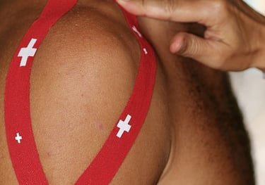 Sports Therapist applying tape to a client's shoulder