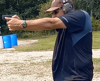 Man using self-defense firearm on range.