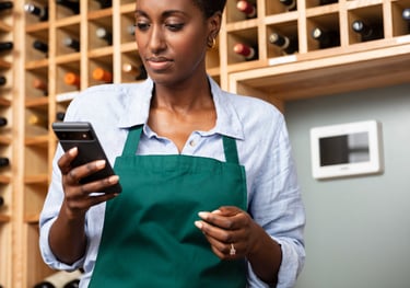 a woman in a green apron and a wine bottle