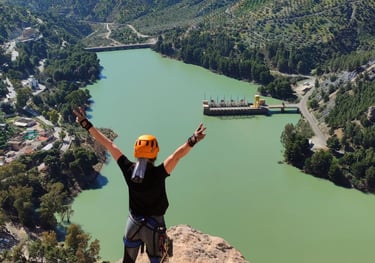 Persona realizando la ferrata del Chorro, con vistas panorámicas a gran altura y paisajes naturales 