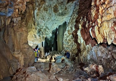 Persona explorando el interior de la Cueva la Tinaja, rodeada de formaciones rocosas impresionantes 