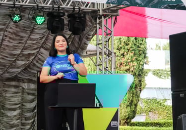 Raabe segurando microfone em palco de evento.