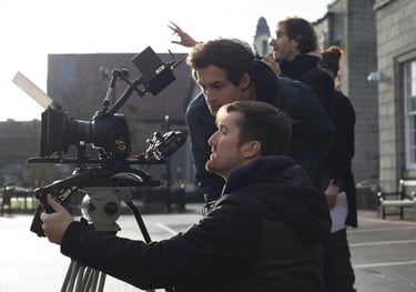 Film production services: a man holding a camera and a second camera