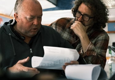 Men sitting at a table, involved in film pre-production discussions
