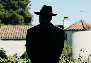 Film and TV production scene featuring a man in a hat under sunlight