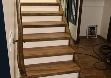 a custom staircase case with a custom carved hardwood railing
