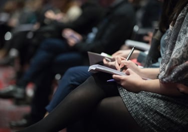 Woman taking notes at a conference