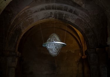 a glass sculpture in the air suspended from the ceiling of the crypt