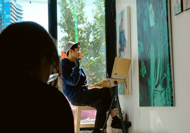 a man sitting on a chair in front of a painting