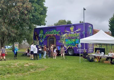 a purple bus parked in a grassy area